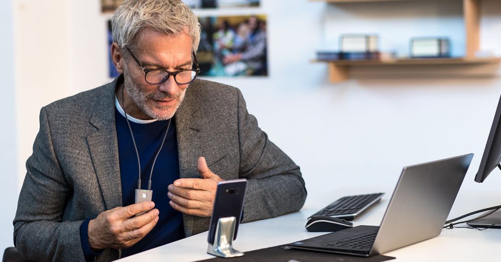 Man using video call on smartphone at desk