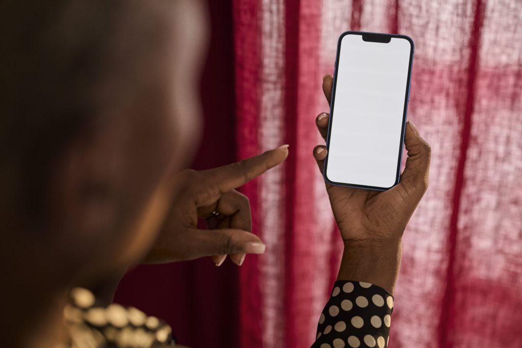 Hand holding smartphone with blank screen