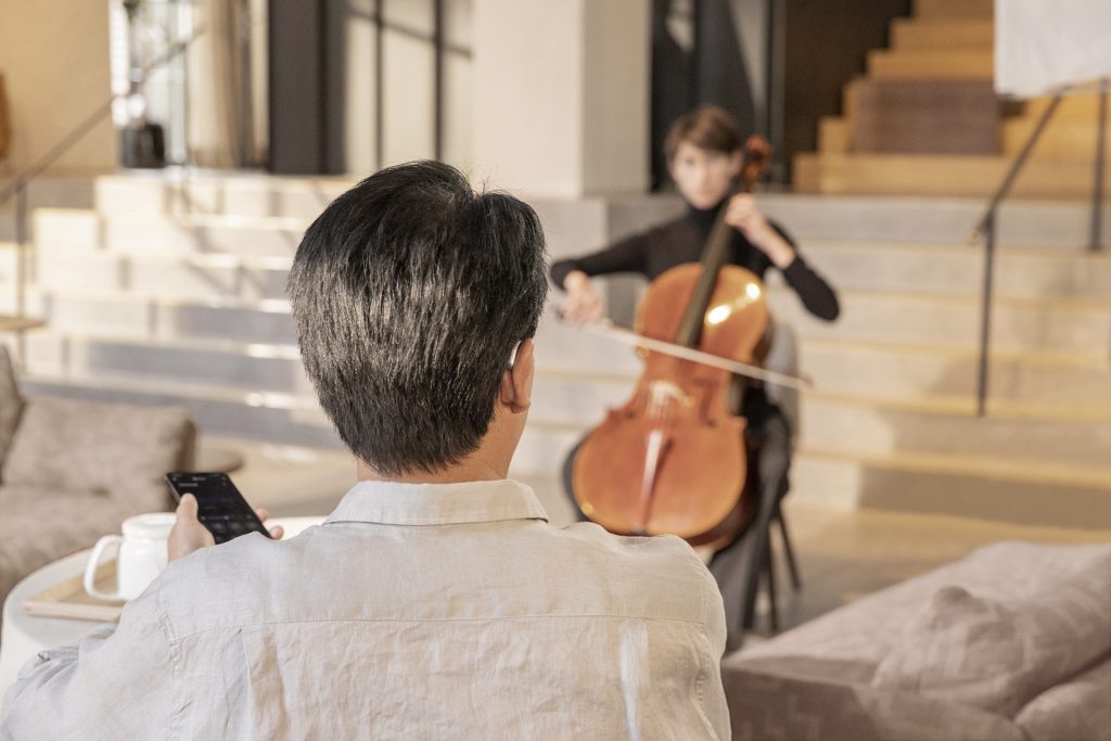 Man viewing musician with smartphone in hand