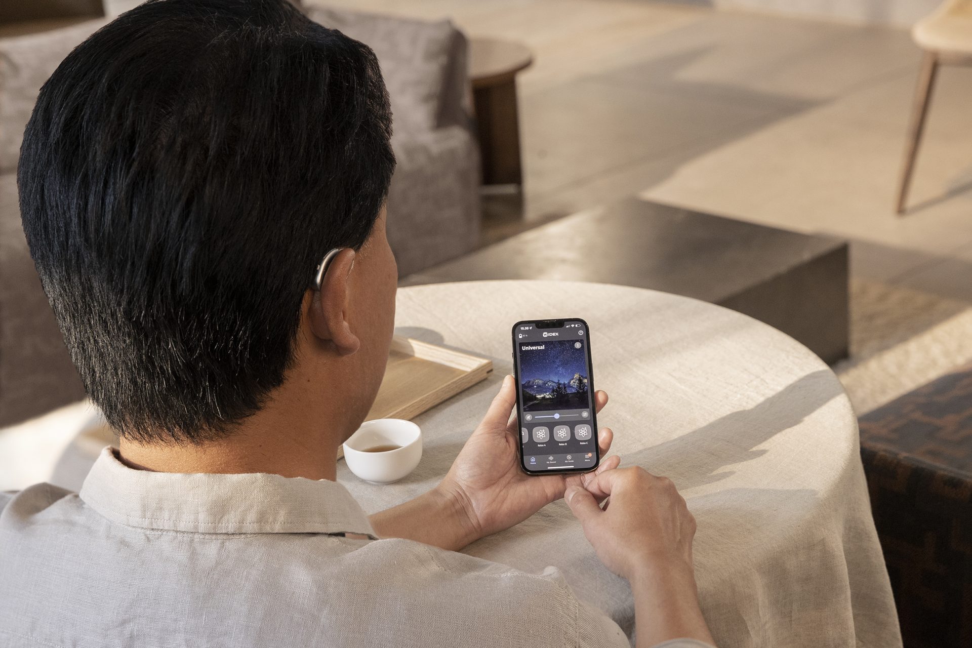 Man using smartphone with hearing aid